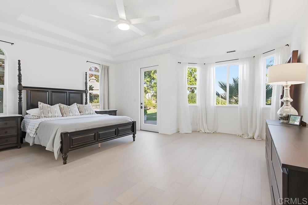 2241 Via Corto Fallbrook, CA 92028 - Photo 35 of 66 a spacious bedroom with a bed a mirror and a flat tv screen