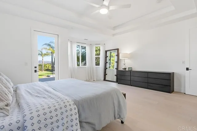 a bed sitting in a bedroom next to a window and a chair