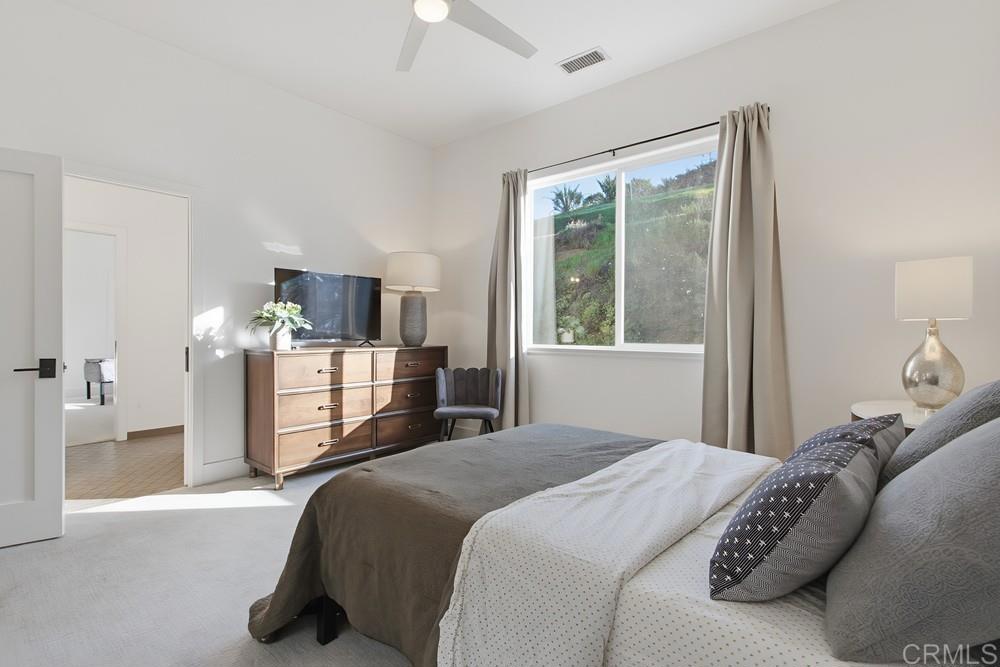 2241 Via Corto Fallbrook, CA 92028 - Photo 42 of 66 a bedroom with a large bed and a flat tv screen