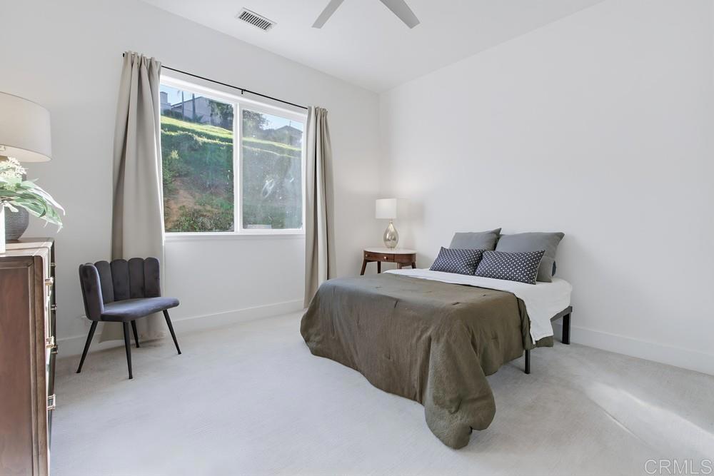 2241 Via Corto Fallbrook, CA 92028 - Photo 43 of 66 a bed sitting in a bedroom next to a window and a chair