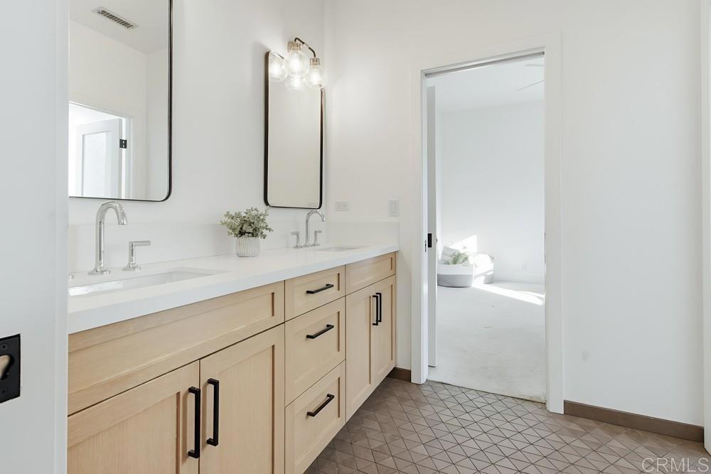2241 Via Corto Fallbrook, CA 92028 - Photo 44 of 66 a bathroom with double sink and a mirror