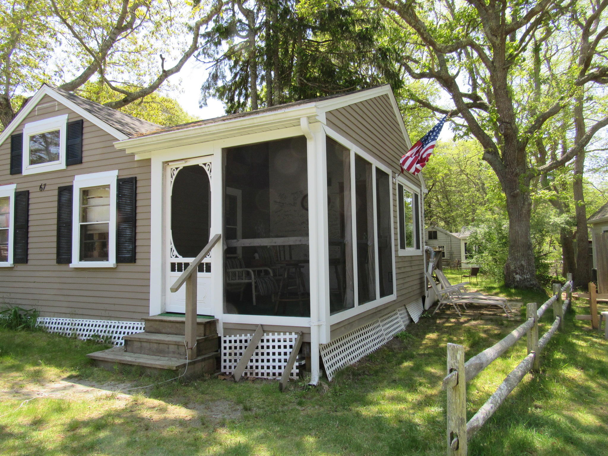 a view of a small house with backyard and furniture
