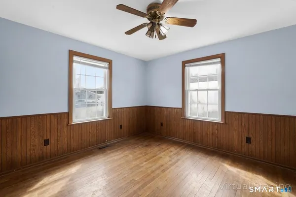 an empty room with windows and fan
