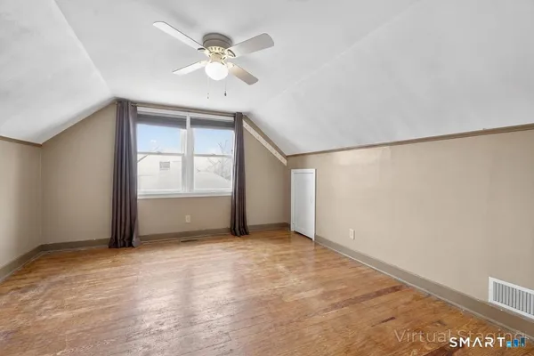 an empty room with windows and fan