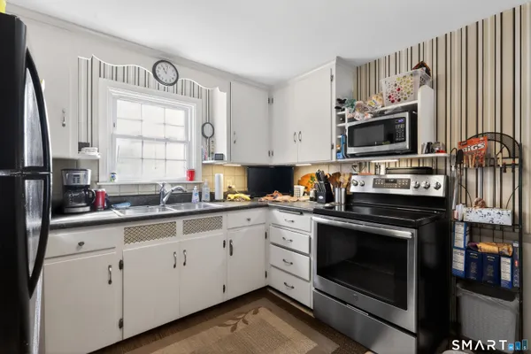 a kitchen with cabinets appliances a sink and a window