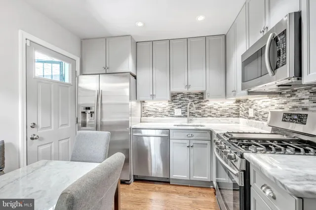 a kitchen with stainless steel appliances granite countertop a stove a sink and a refrigerator