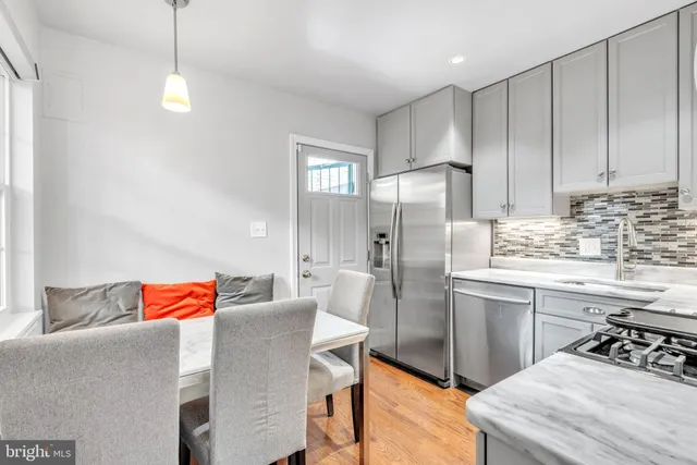 a kitchen with stainless steel appliances granite countertop a sink refrigerator and cabinets