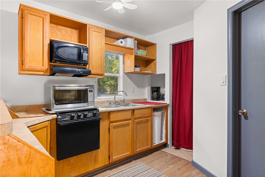 12255 County Road Centerville, TX 75833 - Photo 10 of 26 a kitchen with stainless steel appliances granite countertop a stove top oven a sink and a microwave