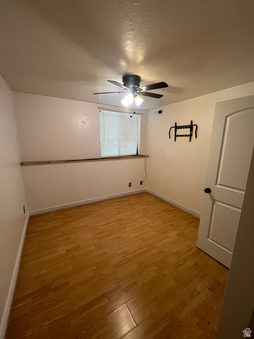 1175 Canyon Road, Unit A 5 Ogden, UT 84404 - Photo 15 of 15 Room featuring wood-finish flooring, a ceiling fan with integrated lighting, a window with horizontal blinds, and a paneled door with black hardware