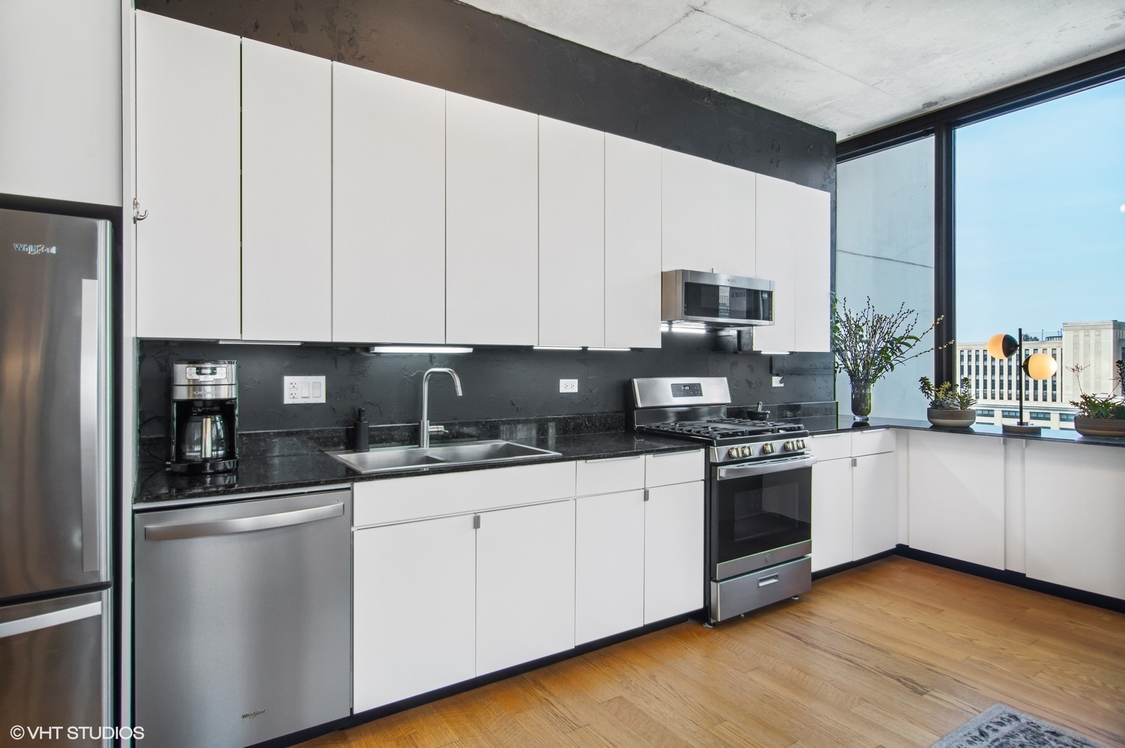 235 West Van Buren Street, Unit 1815 Chicago, IL 60607 - Photo 4 of 17 a kitchen with stainless steel appliances granite countertop a stove a sink and a microwave