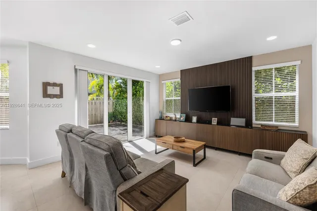 a kitchen with white cabinets and window