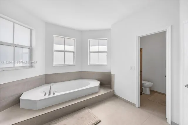 a bedroom with a bed a couch and a window