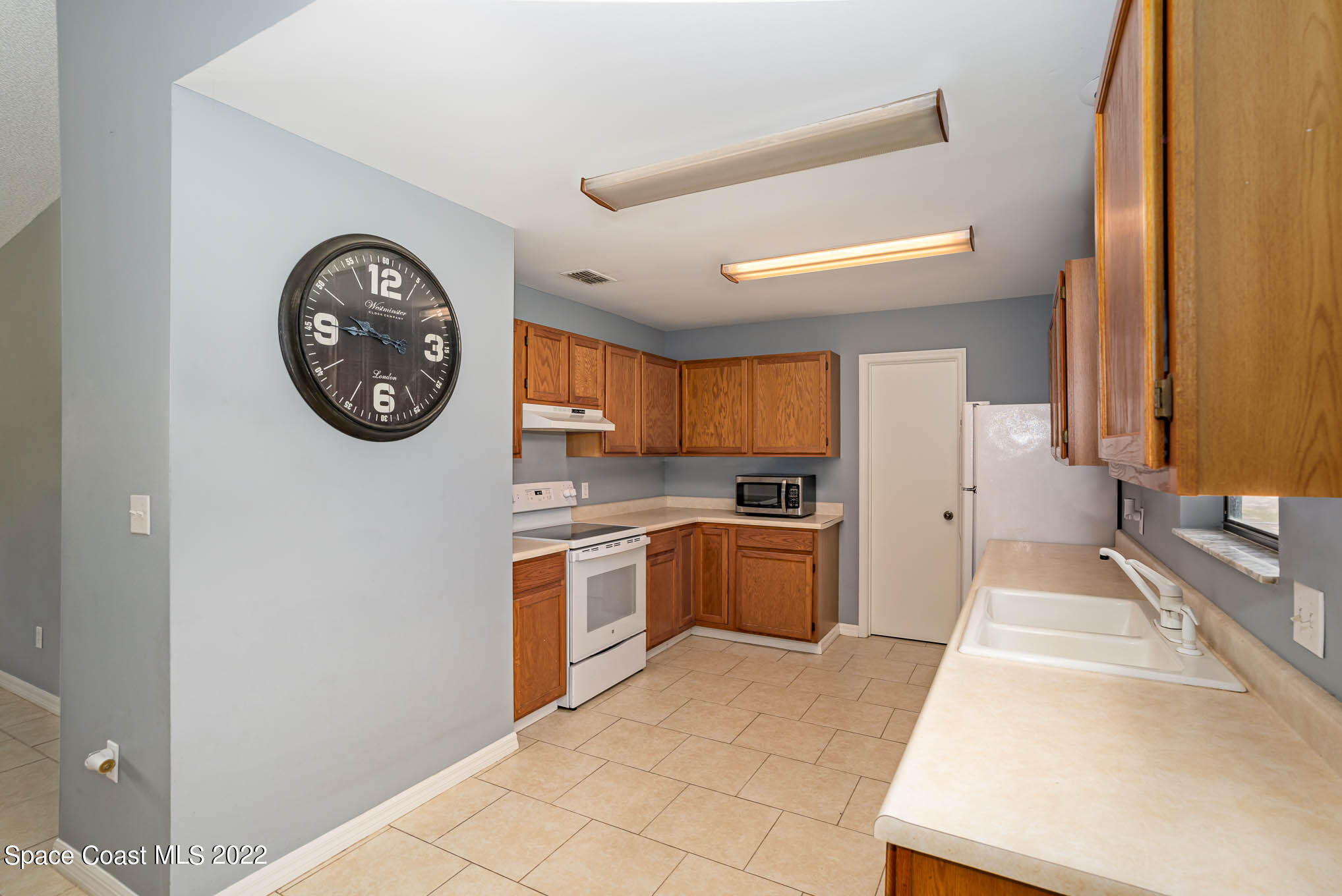 1291 Daton Road Southwest Palm Bay, FL 32908 - Photo 9 of 22 a large white kitchen with a sink a stove and a refrigerator