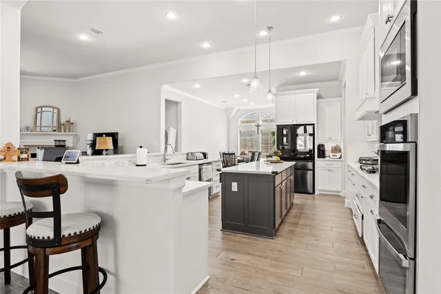 a kitchen with cabinets and chairs