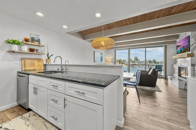 a kitchen with stainless steel appliances granite countertop a stove and white cabinets with wooden floor