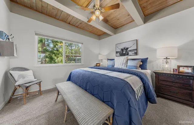 a bedroom with a bed a chair and a large window