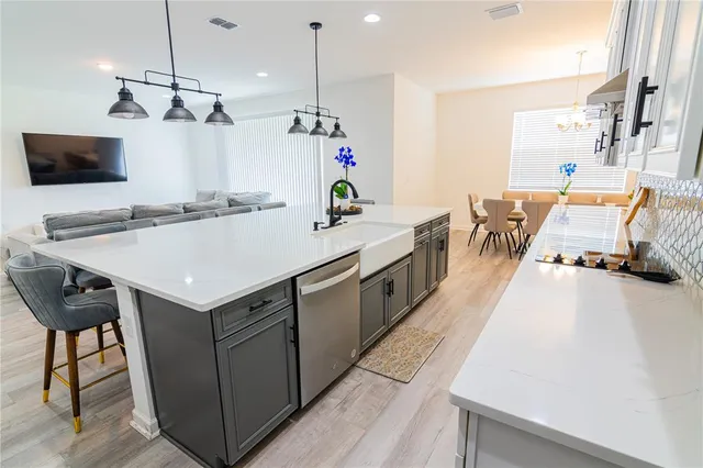 a living room with kitchen island furniture and a chandelier