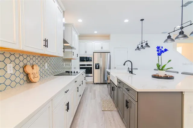 a kitchen with stainless steel appliances granite countertop a stove and white cabinets