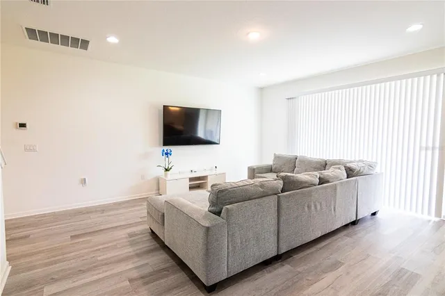a kitchen with stainless steel appliances kitchen island granite countertop a dining table chairs and white cabinets