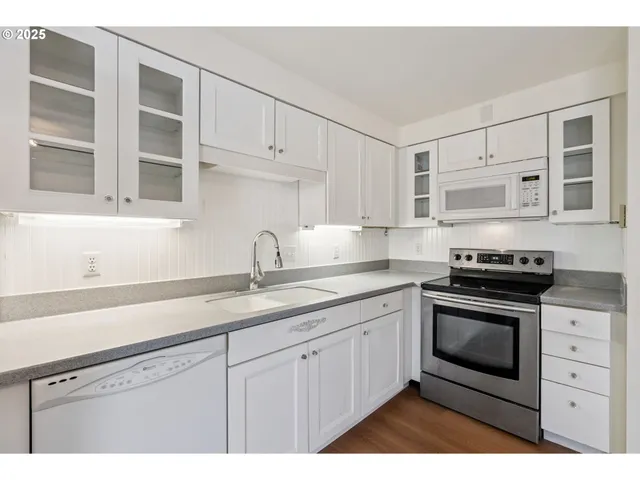 a kitchen with cabinets stainless steel appliances and a sink