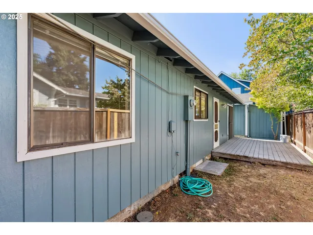 a backyard of a house wit a table and chairs and wooden fence