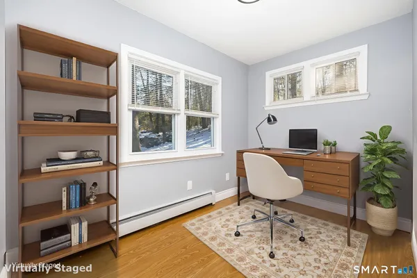 a workspace with furniture bookshelf and a window