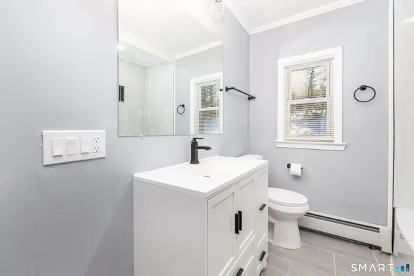a bathroom with a sink toilet and window