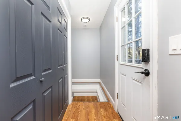 a view of a hallway with a white walls and wooden floor