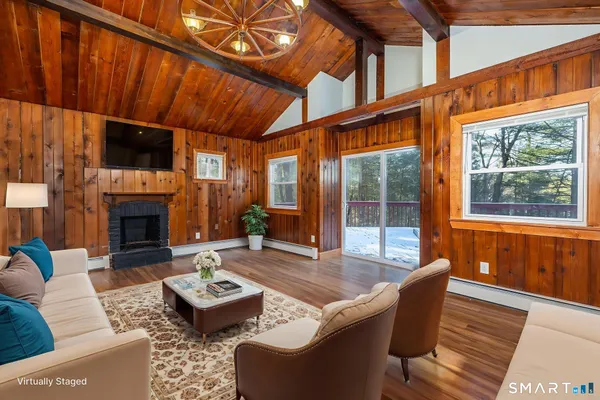a living room with furniture a fireplace and a flat screen tv