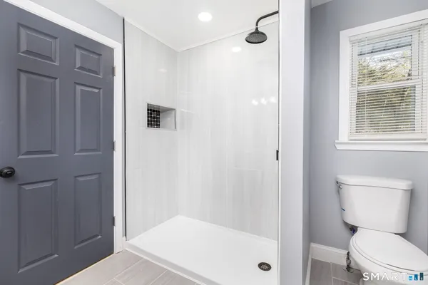 a bathroom with a toilet and a shower