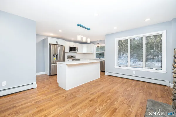a view of a kitchen with a sink a refrigerator and window