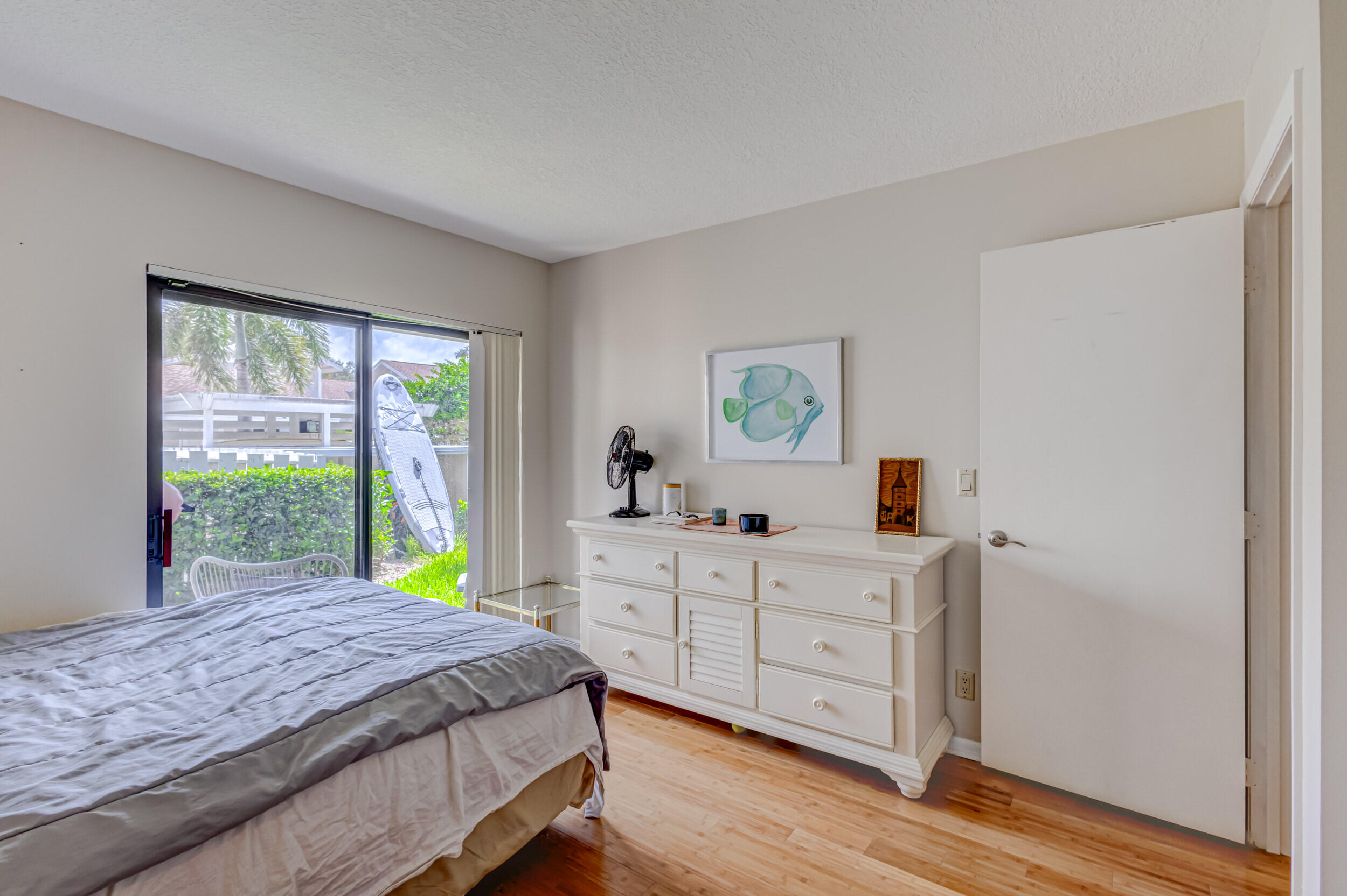 3793 Cape Pointe Circle Jupiter, FL 33477 - Photo 12 of 16 a spacious bedroom with a bed and a dresser next to a window