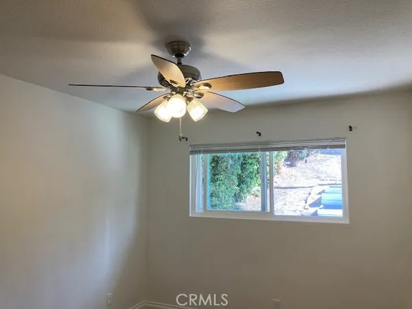 a view of a room with a ceiling fan and a window