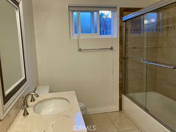 a bathroom with a tub a sink and a mirror