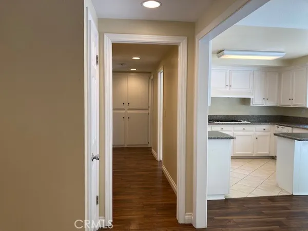a view of a kitchen with white cabinets and wooden floor