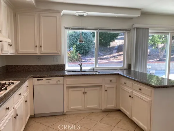 a kitchen with granite countertop white cabinets and white appliances