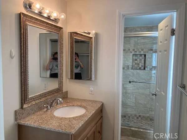 a bathroom with a granite countertop sink and a mirror