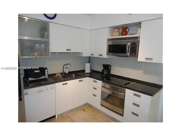 a kitchen with stainless steel appliances granite countertop a refrigerator and a stove