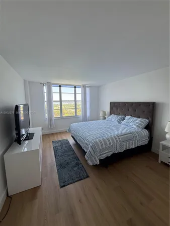 a bedroom with a large bed and a large window