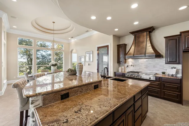a kitchen with stainless steel appliances granite countertop sink stove and wooden cabinets