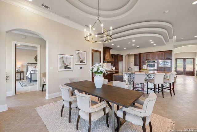 a view of a dining room with furniture a chandelier and wooden floor