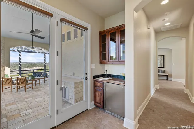 a kitchen with stainless steel appliances granite countertop a refrigerator and a view of living room