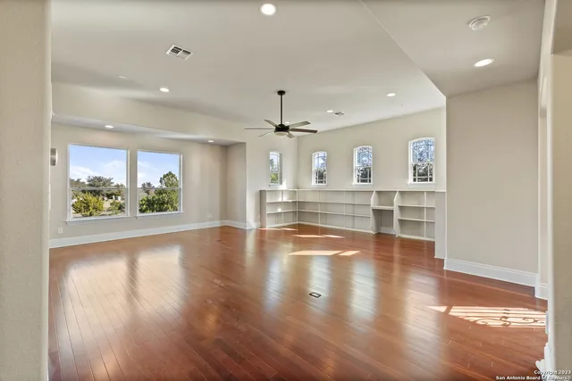 a view of empty room with wooden floor and windows