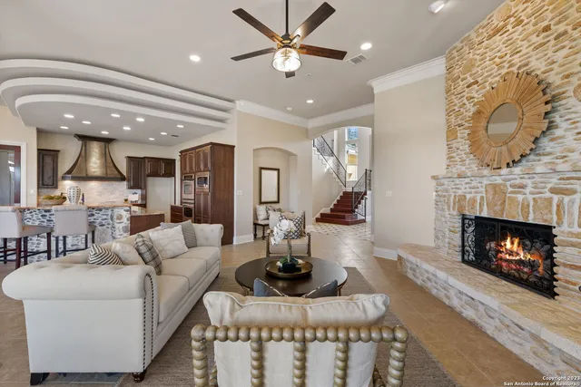 a living room with furniture a fireplace and a ceiling fan