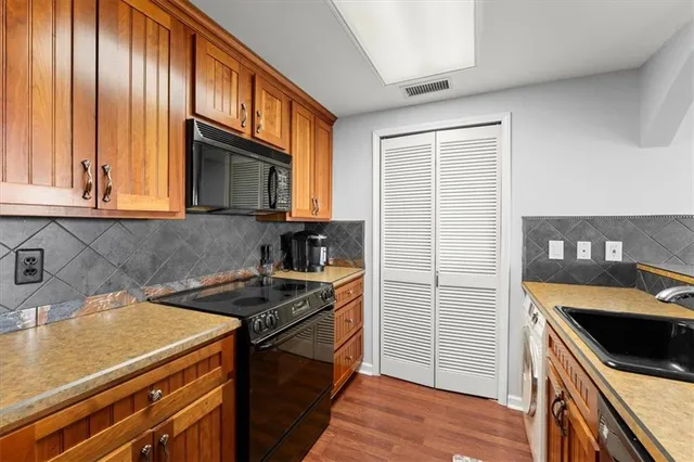 a kitchen with stainless steel appliances granite countertop a sink and a refrigerator