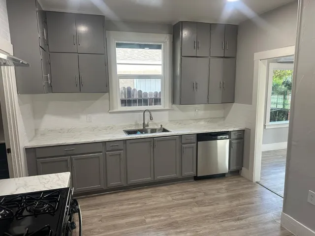 a kitchen with a sink cabinets and wooden floor