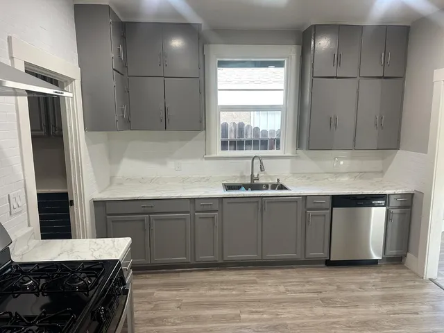 a kitchen with kitchen island granite countertop a sink stainless steel appliances and cabinets
