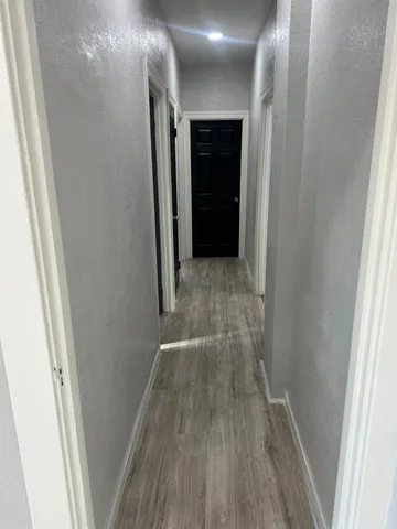 a view of hallway with wooden floor
