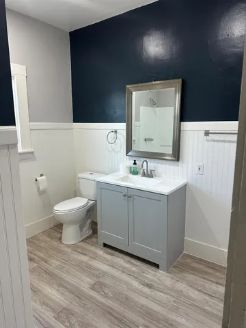 a bathroom with a toilet sink and mirror