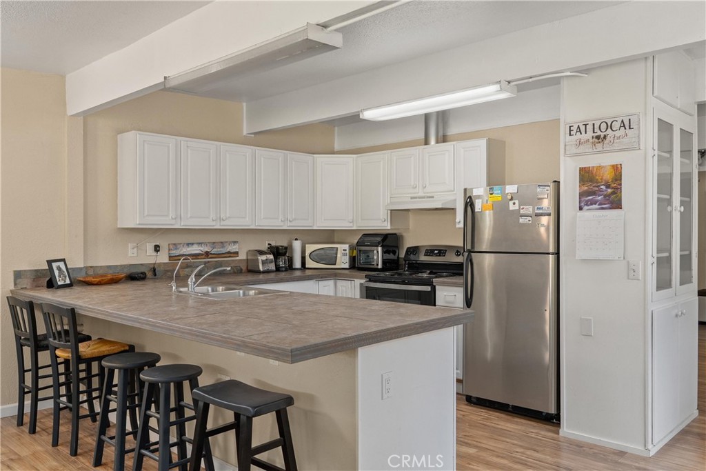 5574 California Street Chico, CA 95973 - Photo 11 of 30 a kitchen with stainless steel appliances granite countertop a refrigerator a sink a stove a dining table and chairs